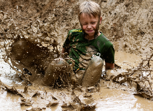 jongen die in de modder valt