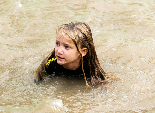 meisje die door modderig water zwemt