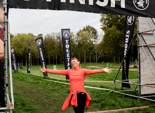 een vrouw die arriveert bij de finish van de trail run van strong viking hardlopen voor beginners hardlopen opbouwen